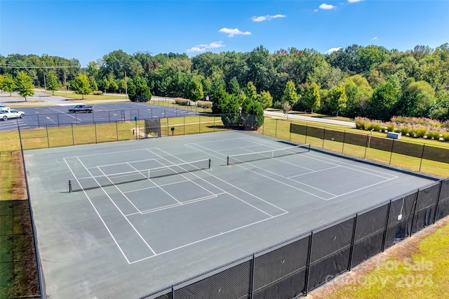 view of sport court with a lawn