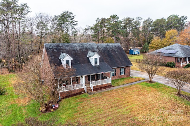 cape cod house with a porch and a front lawn