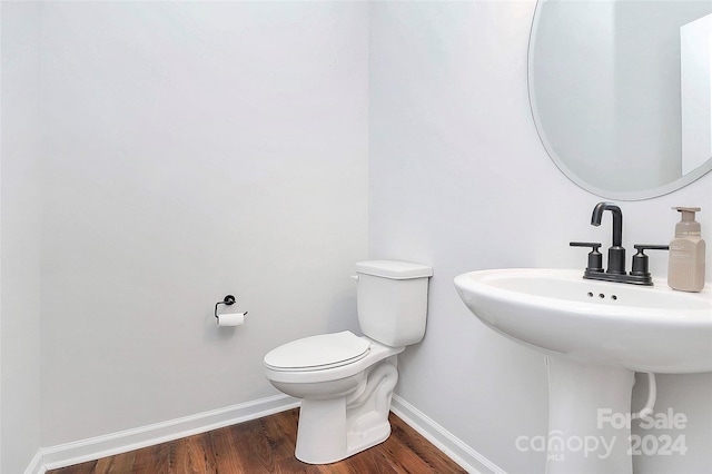 bathroom with hardwood / wood-style flooring, toilet, and sink