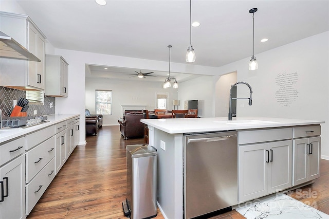 kitchen with a center island with sink, decorative light fixtures, ceiling fan, and stainless steel appliances