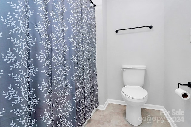 bathroom featuring a shower with shower curtain and toilet