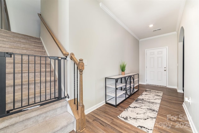 foyer with ornamental molding and dark wood-type flooring