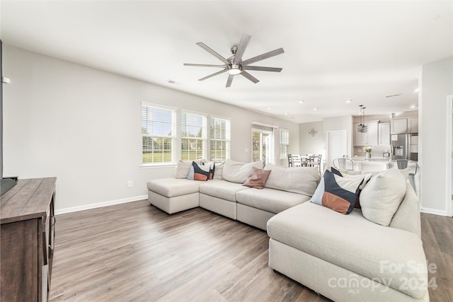 living room featuring ceiling fan, a healthy amount of sunlight, and hardwood / wood-style flooring