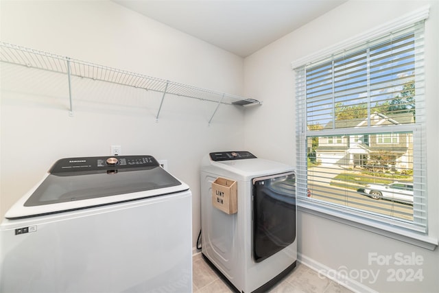 laundry area featuring washing machine and dryer and light tile patterned flooring