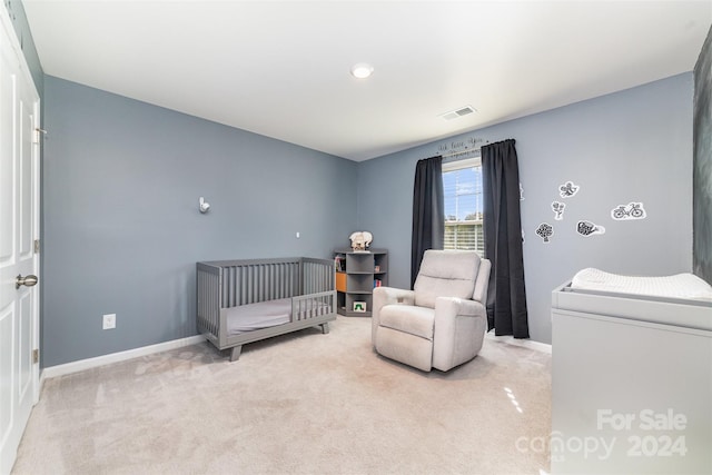 bedroom featuring light colored carpet and a crib