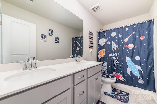 bathroom with tile patterned flooring, vanity, and toilet