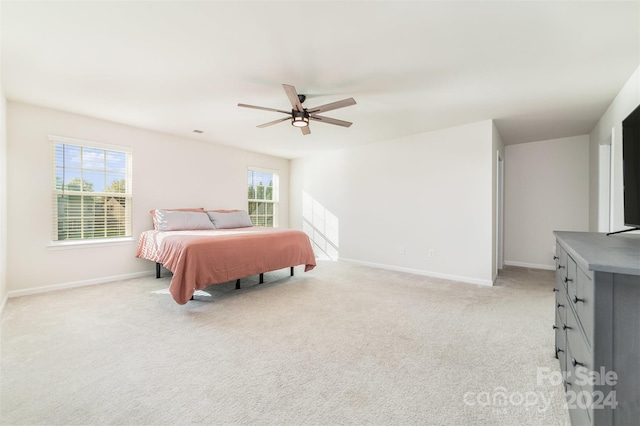 carpeted bedroom with multiple windows and ceiling fan