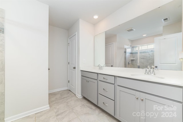 bathroom featuring tile patterned floors, vanity, and a shower with shower door