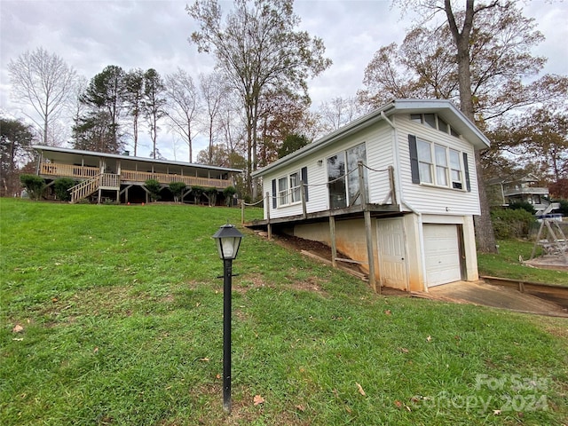 view of property exterior featuring a yard, a deck, and a garage