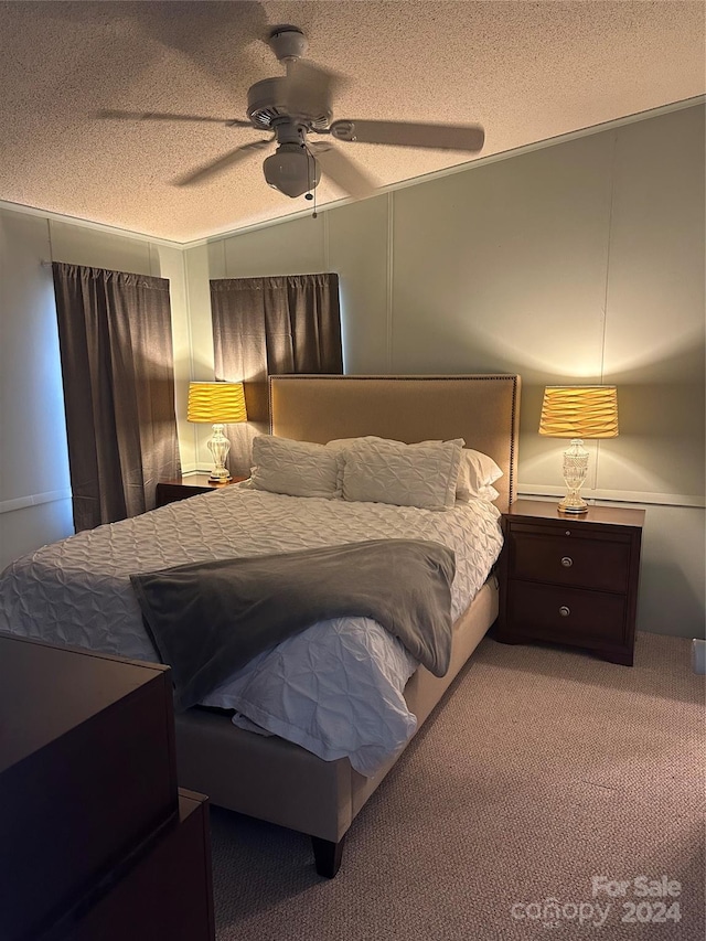 bedroom with ceiling fan, light carpet, and a textured ceiling