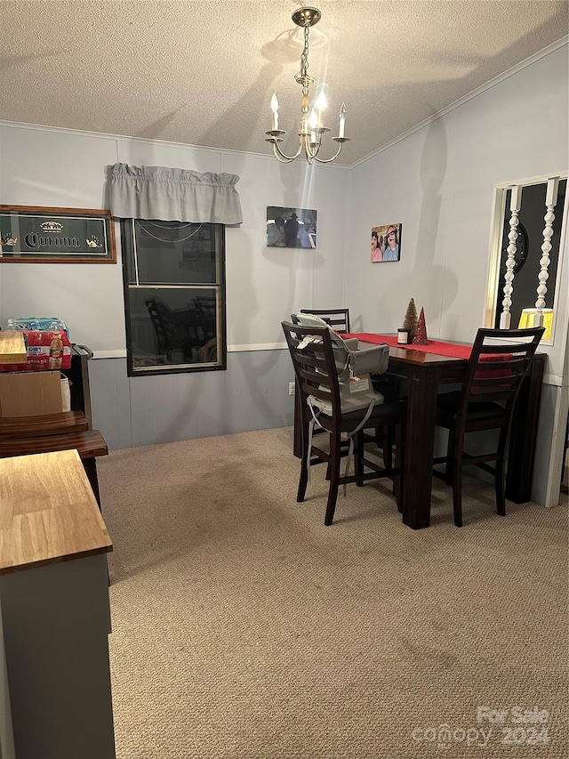 carpeted dining room featuring ornamental molding, a textured ceiling, and an inviting chandelier