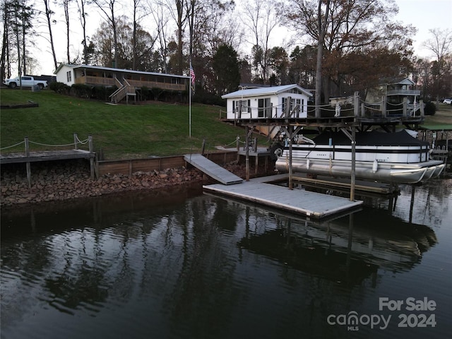 view of dock with a lawn and a deck with water view