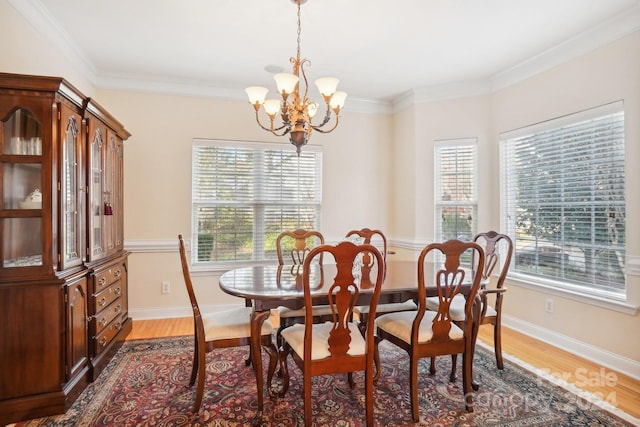 dining area featuring dark hardwood / wood-style floors, ornamental molding, and an inviting chandelier