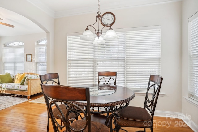 dining space featuring crown molding, ceiling fan with notable chandelier, and hardwood / wood-style flooring