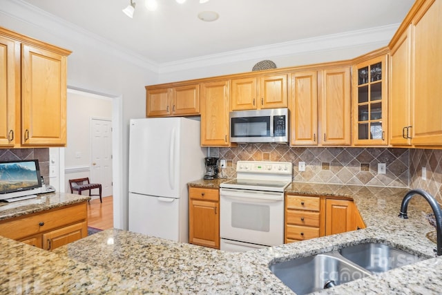 kitchen featuring white appliances, backsplash, sink, light stone countertops, and ornamental molding