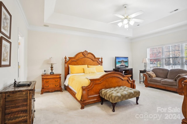 carpeted bedroom with a raised ceiling, ceiling fan, and crown molding