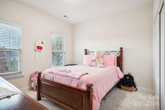 carpeted bedroom featuring multiple windows