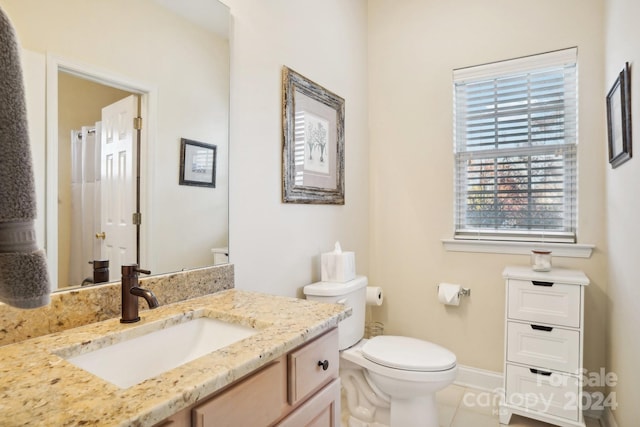 bathroom with tile patterned flooring, vanity, and toilet