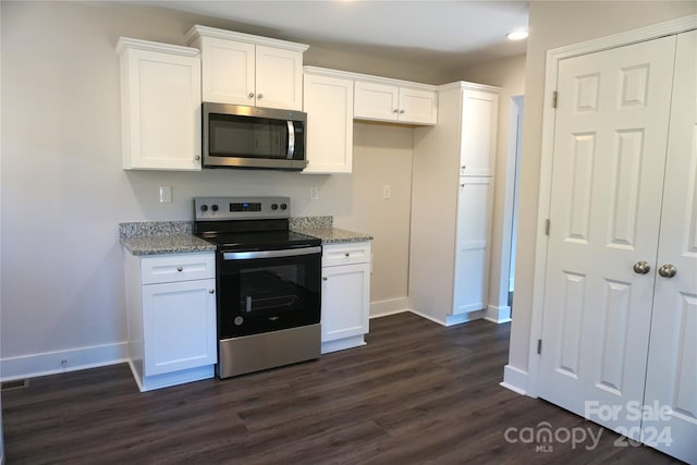 kitchen featuring light stone countertops, white cabinets, dark wood-type flooring, and appliances with stainless steel finishes