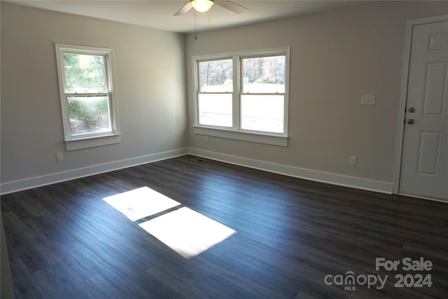 spare room featuring a wealth of natural light, dark wood-type flooring, and ceiling fan