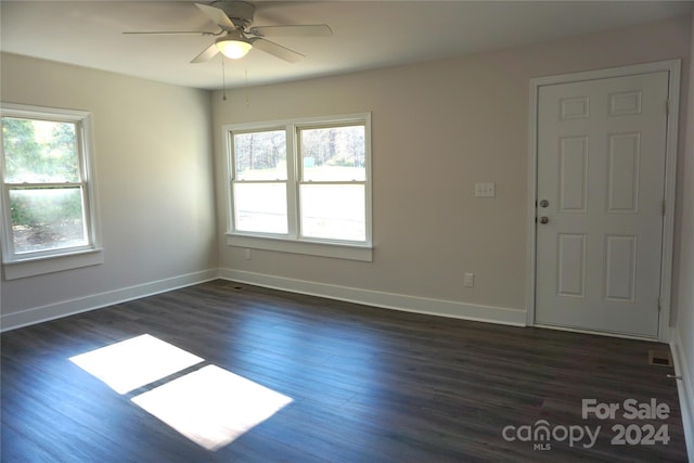 spare room with dark hardwood / wood-style flooring, ceiling fan, and plenty of natural light