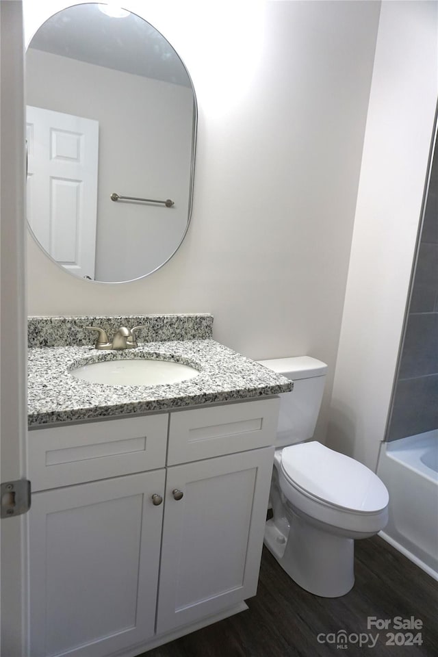 bathroom with hardwood / wood-style flooring, vanity, and toilet