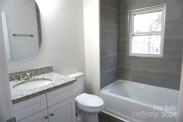 full bathroom with vanity, tiled shower / bath combo, and toilet