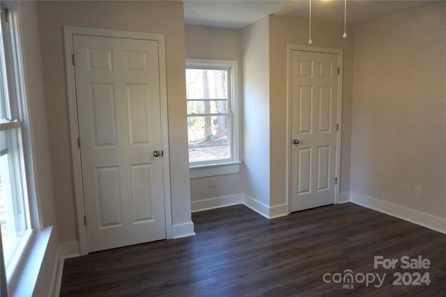 unfurnished bedroom with dark hardwood / wood-style flooring