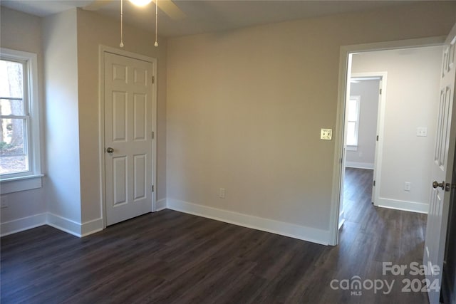 empty room with dark hardwood / wood-style flooring