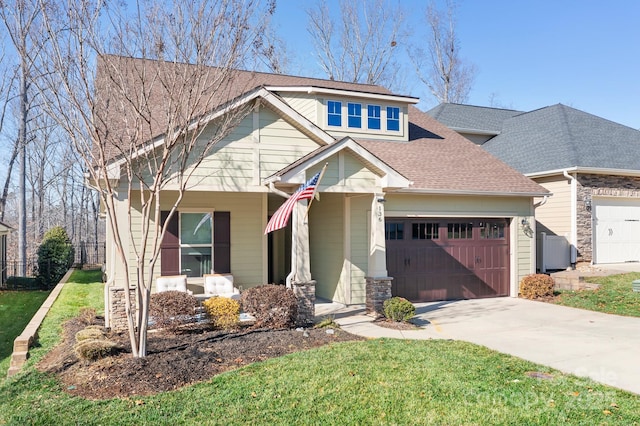 view of front of property featuring a front lawn, covered porch, and a garage