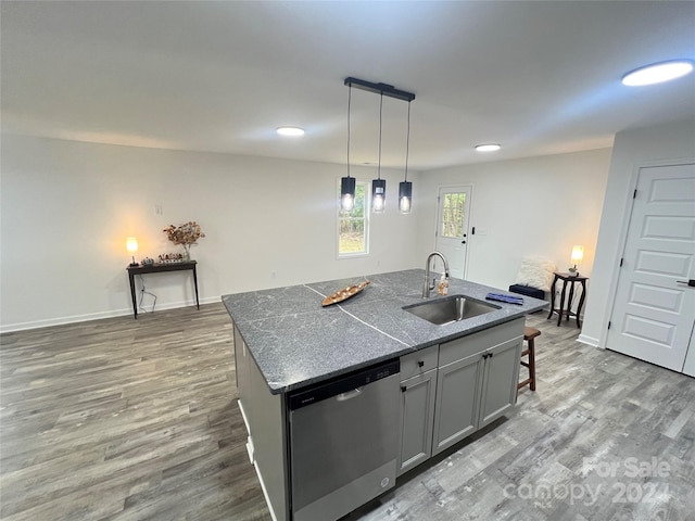 kitchen with gray cabinetry, hardwood / wood-style floors, a center island with sink, sink, and stainless steel dishwasher