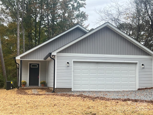 view of front of home with central AC unit and a garage