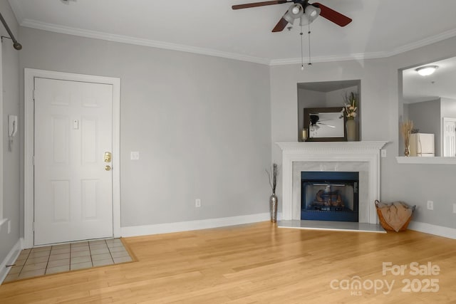 unfurnished living room with hardwood / wood-style floors, ceiling fan, crown molding, and a fireplace