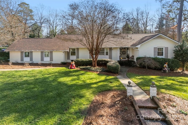 ranch-style home featuring a front lawn and stucco siding