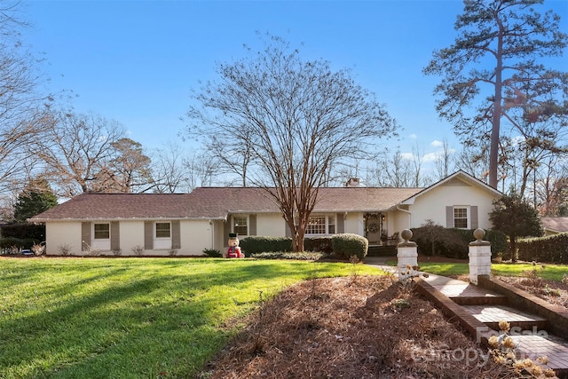 ranch-style home with a front lawn and stucco siding