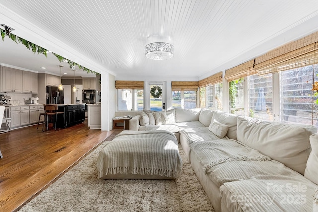 living area featuring dark wood-style floors, wooden ceiling, and ornamental molding