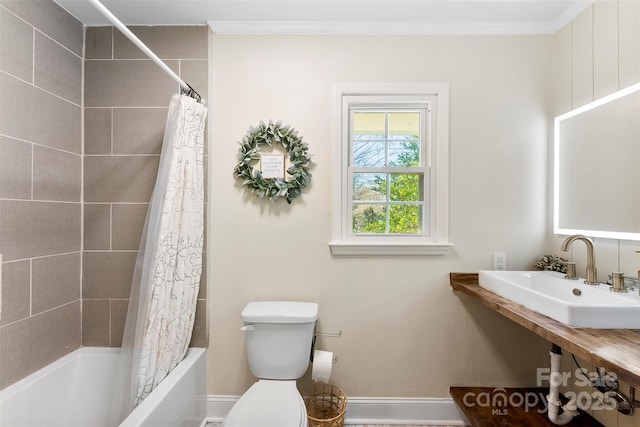 full bath with ornamental molding, shower / tub combo, a sink, and toilet