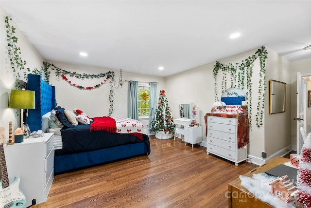 bedroom with baseboards, wood finished floors, and recessed lighting