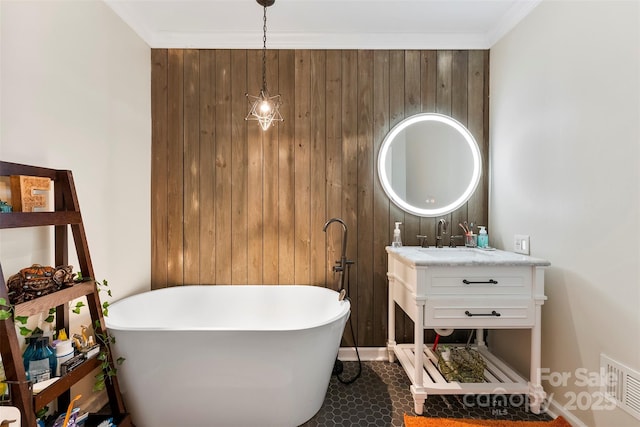 bathroom featuring a freestanding bath, ornamental molding, vanity, and visible vents