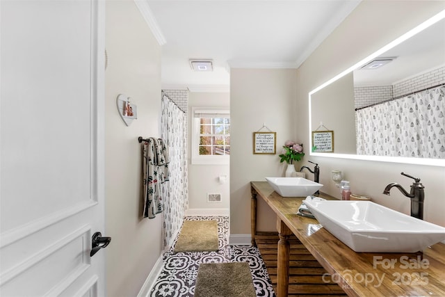 full bathroom featuring ornamental molding, a sink, visible vents, and baseboards