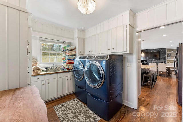 laundry area featuring washing machine and dryer, dark wood finished floors, a sink, and recessed lighting