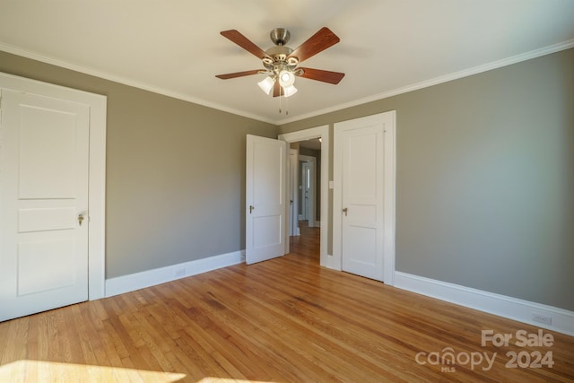 unfurnished bedroom featuring ceiling fan, crown molding, and light wood-type flooring