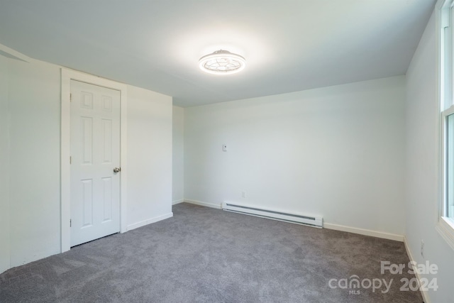 carpeted spare room with baseboard heating