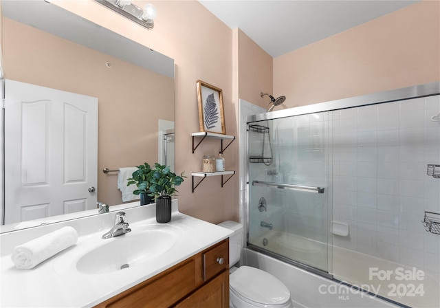 full bathroom with vanity, toilet, and bath / shower combo with glass door