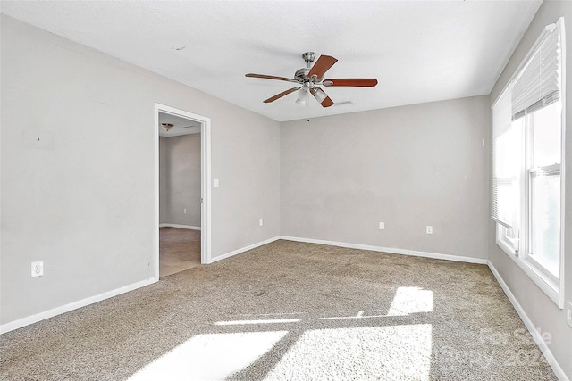 carpeted spare room featuring a textured ceiling and ceiling fan