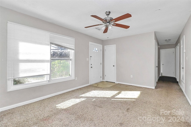 empty room featuring ceiling fan and carpet floors