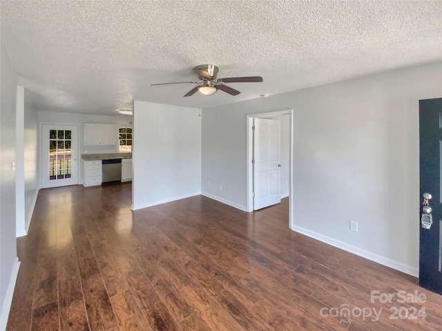 unfurnished living room featuring ceiling fan, dark hardwood / wood-style flooring, and a textured ceiling