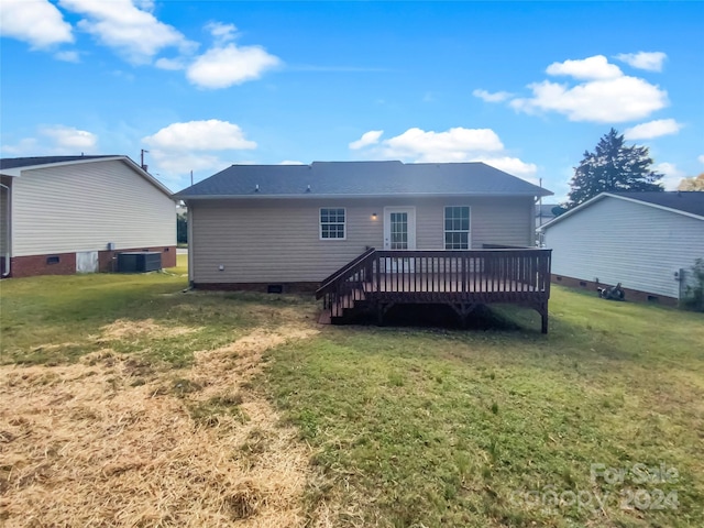 rear view of house featuring central AC, a deck, and a lawn