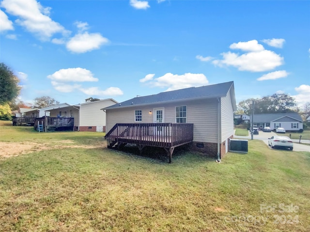 back of property with a yard, central AC unit, and a wooden deck