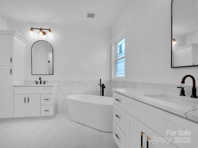 bathroom featuring a bathtub, tile walls, and vanity